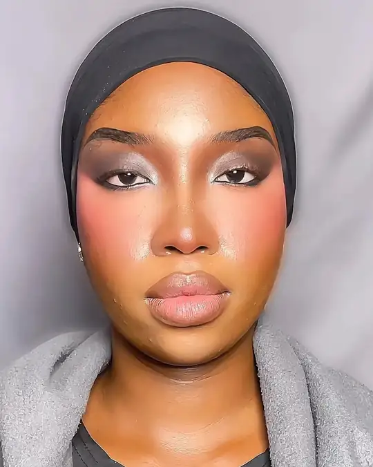 Pink blush and nude lip on a woman in a grey scarf